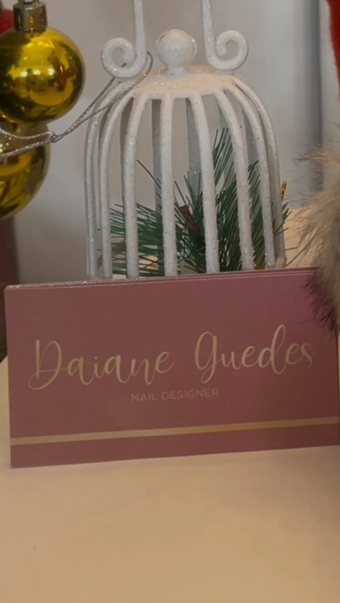 Caixa rosé com o nome Daiane Guedes Nail Designer em dourado