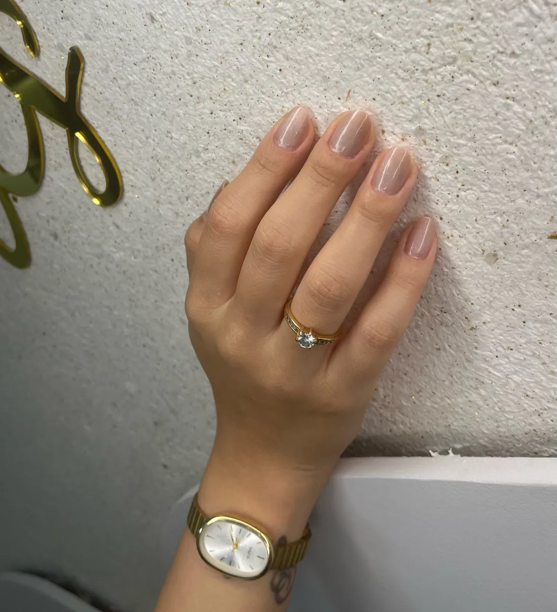 Nude magnético em mão com relógio dourado